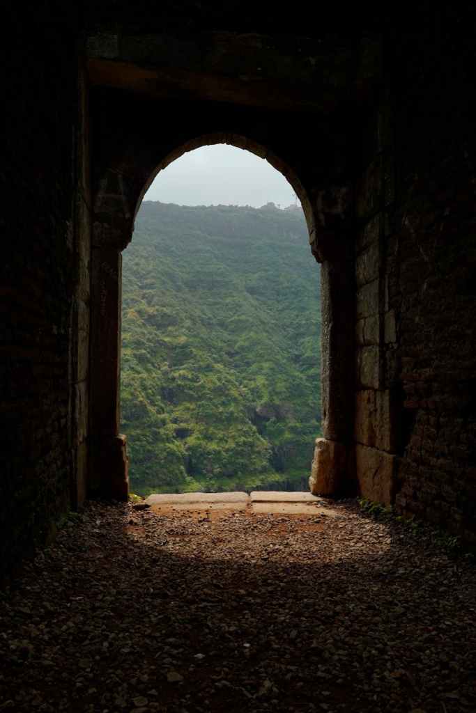 ancient stone archway overlooking verdant hills