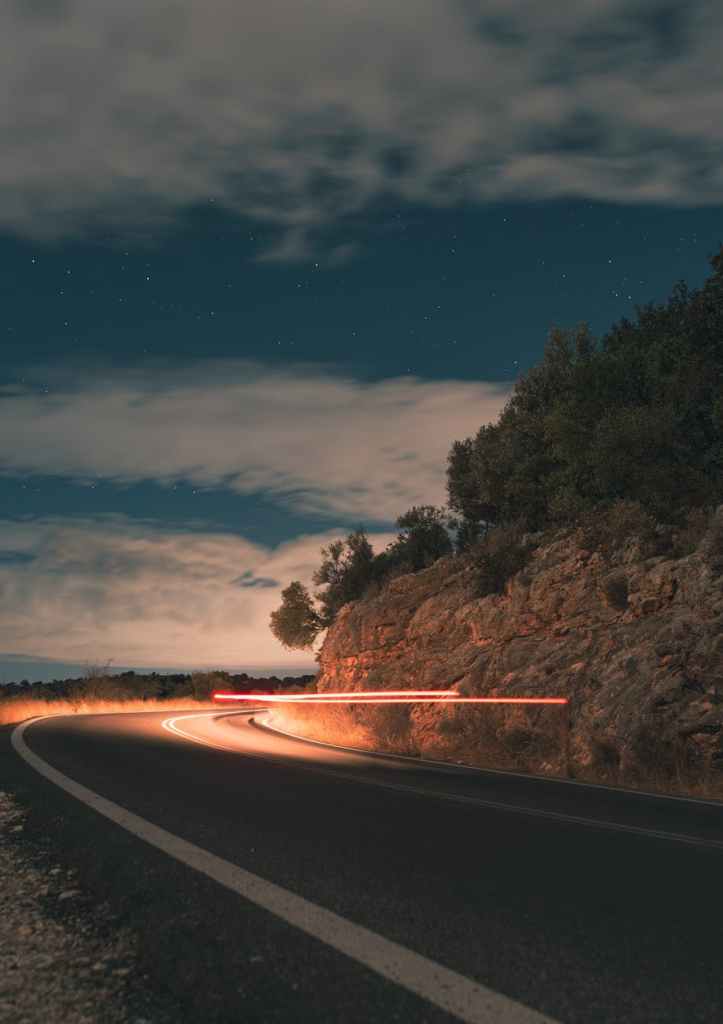 scenic curved road at night with light trails